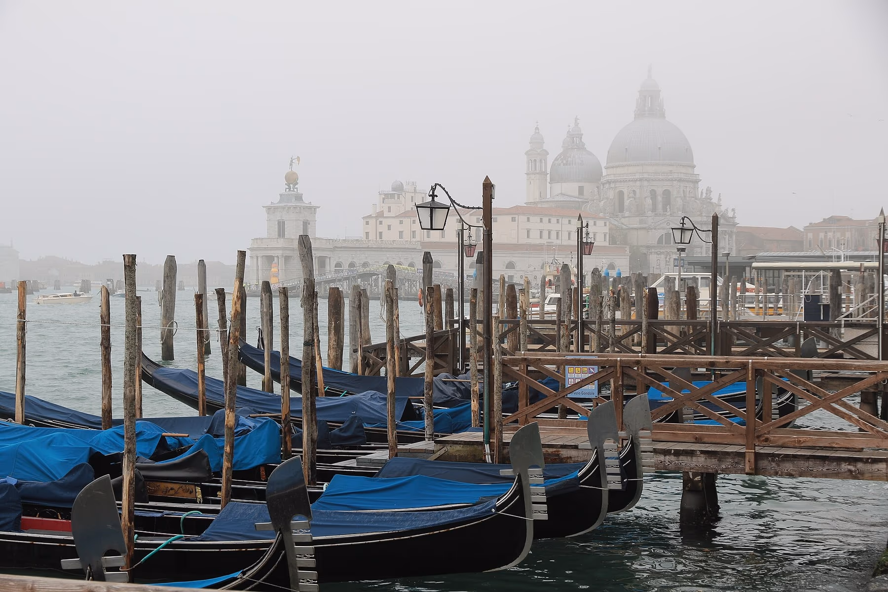 Gondola in un canale stretto di Venezia tra palazzi